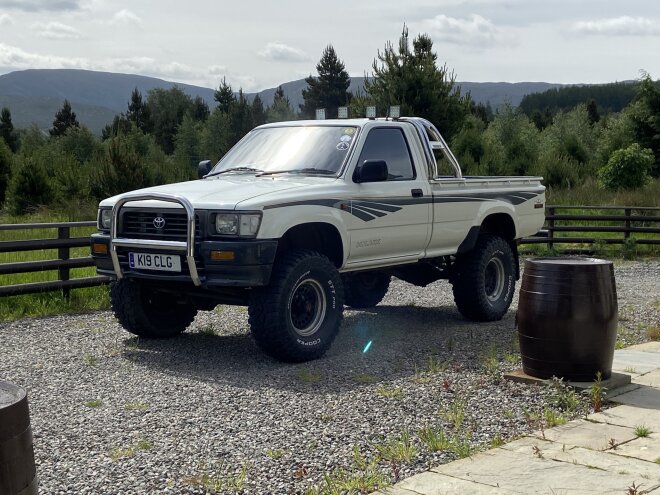 A photograph of a 1997 Toyota Hilux LN105 in the countryside